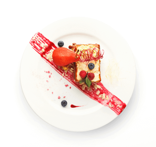A plant-based dessert topped with berries stis on a white plate