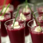 Red fruit drinks in glasses with green stems