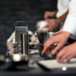 Chefs working in a professional kitchen with a grater