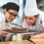 Pastry students looking at baked chocolate dessert