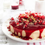 dessert cake with red sauce, cherries, and sliced almonds