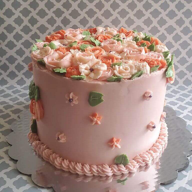 A pink cake with floral design.