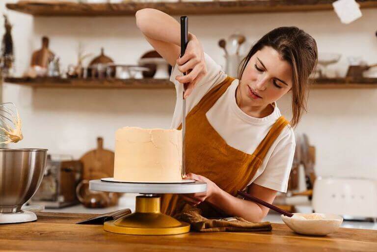 Pastry chef in a kitchen icing a cake