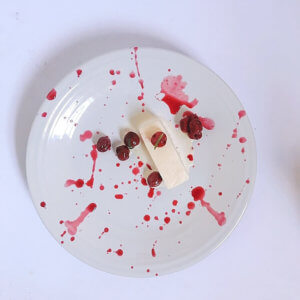 Overhead view of deconstructed Cherries Jubilee on a white plate