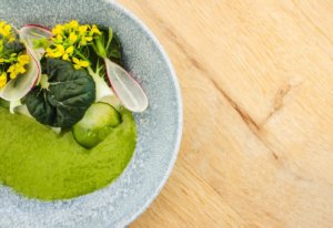 Plant-based meal served in a bowl with fruit and vegetables as a topping