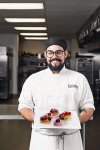 Escoffier student holding their dessert creations on a white plate