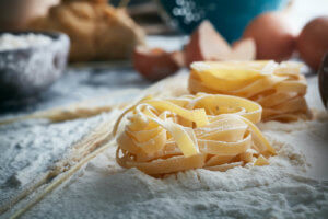 Close up photo of pasta noddles sitting in flour