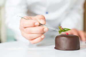 Pastry Chef adds the finishing touches to a chocolate pastry