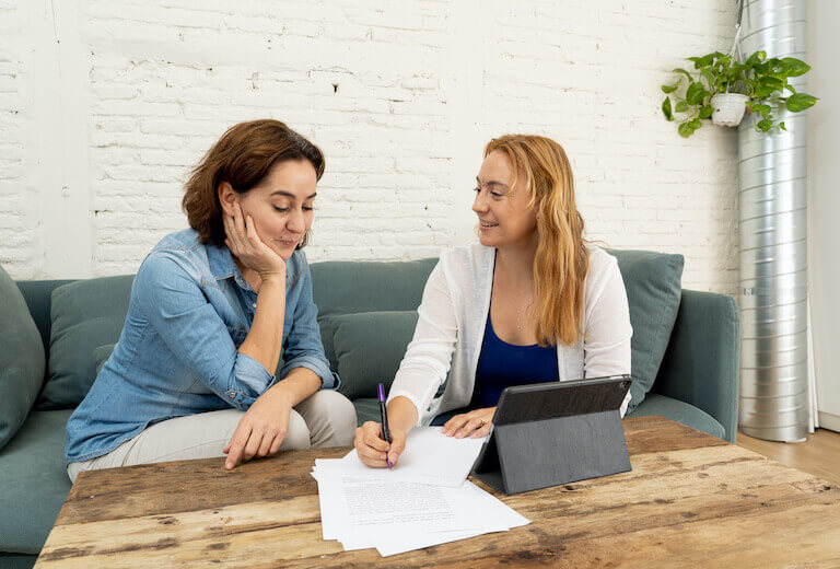 A nutrition coach writing and working with a client as they sit down