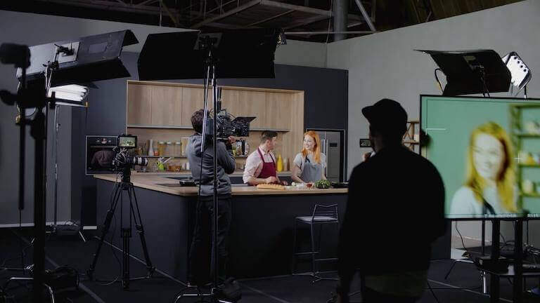 Cameras filming cooking show, chefs with apron