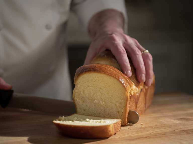 Chef cutting brioche bread with knife
