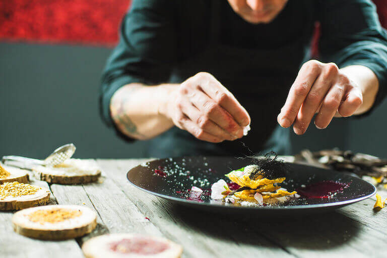 Close-up of male chef plating a molecular dish