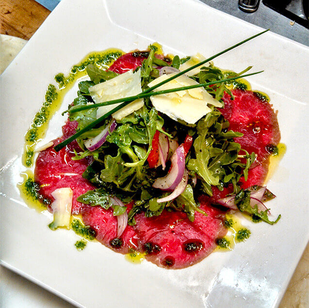 Beef Carpaccio with local grass fed beef, arugula, truffle oil and Prima Donna cheese
