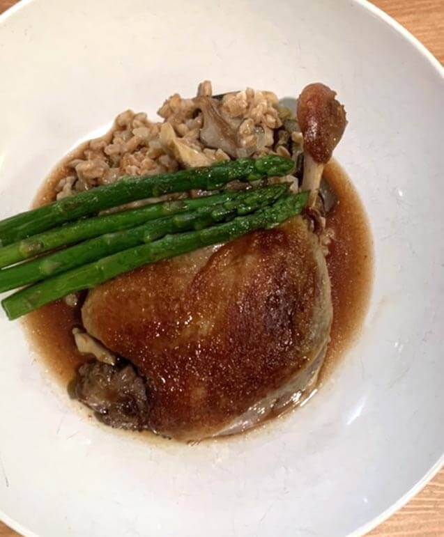 Duck leg confit on white plate