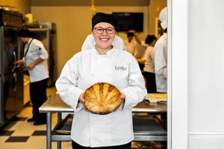 Escoffier baking and pastry student holding baked bread