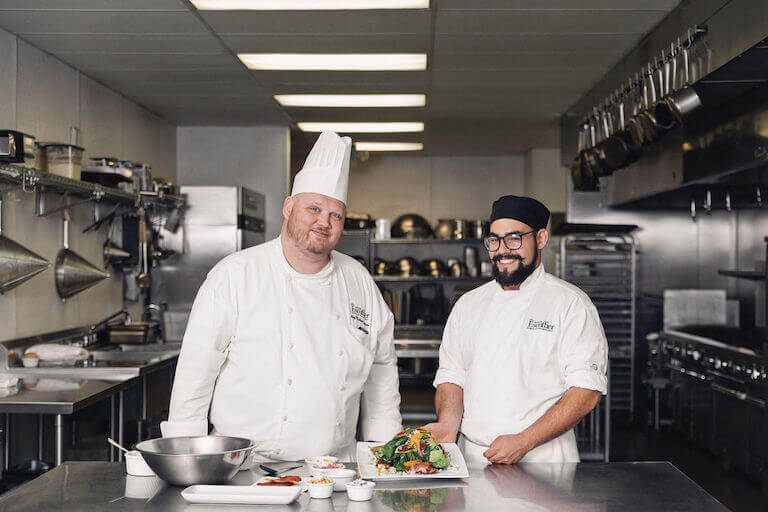 https://www.escoffier.edu/wp-content/uploads/2022/01/Escoffier-chef-instructor-and-smiling-male-culinary-student-with-mixed-vegetable-plate-768.jpg