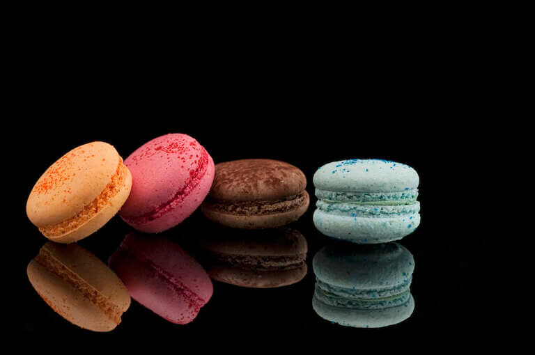 Four colorful Macarons on a black table