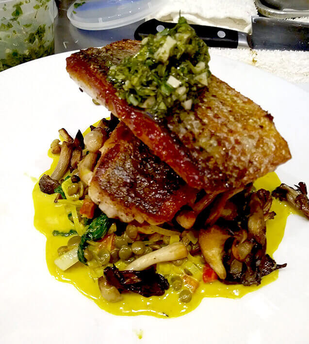Pan Seared Striped Bass with wild mushrooms, curried lentils and a cilantro lime gremolata