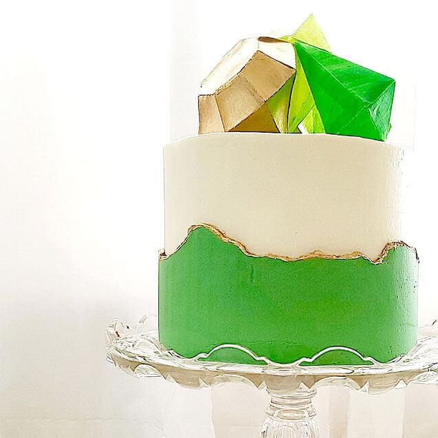green gold birthday cake on glass stand