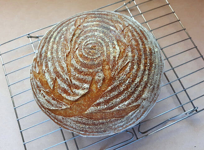 rustic sourdough boule on a wire rack