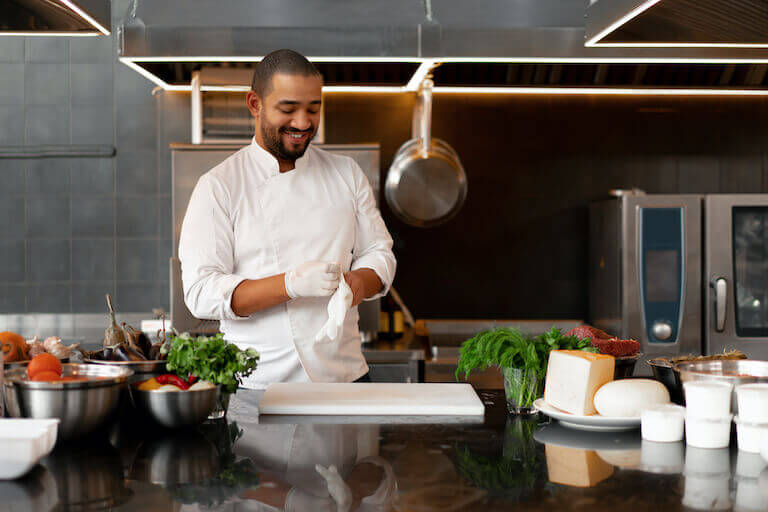 A Chef putting on protective gloves before preparing a meal