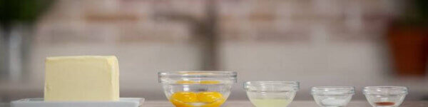 A row of prepared ingredients in small bowls on a countertop