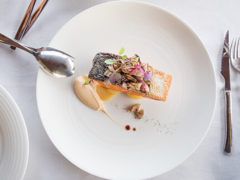 A salmon meal plated on a white dish