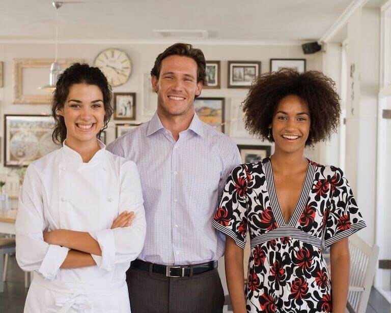 Chef and staff standing together smiling