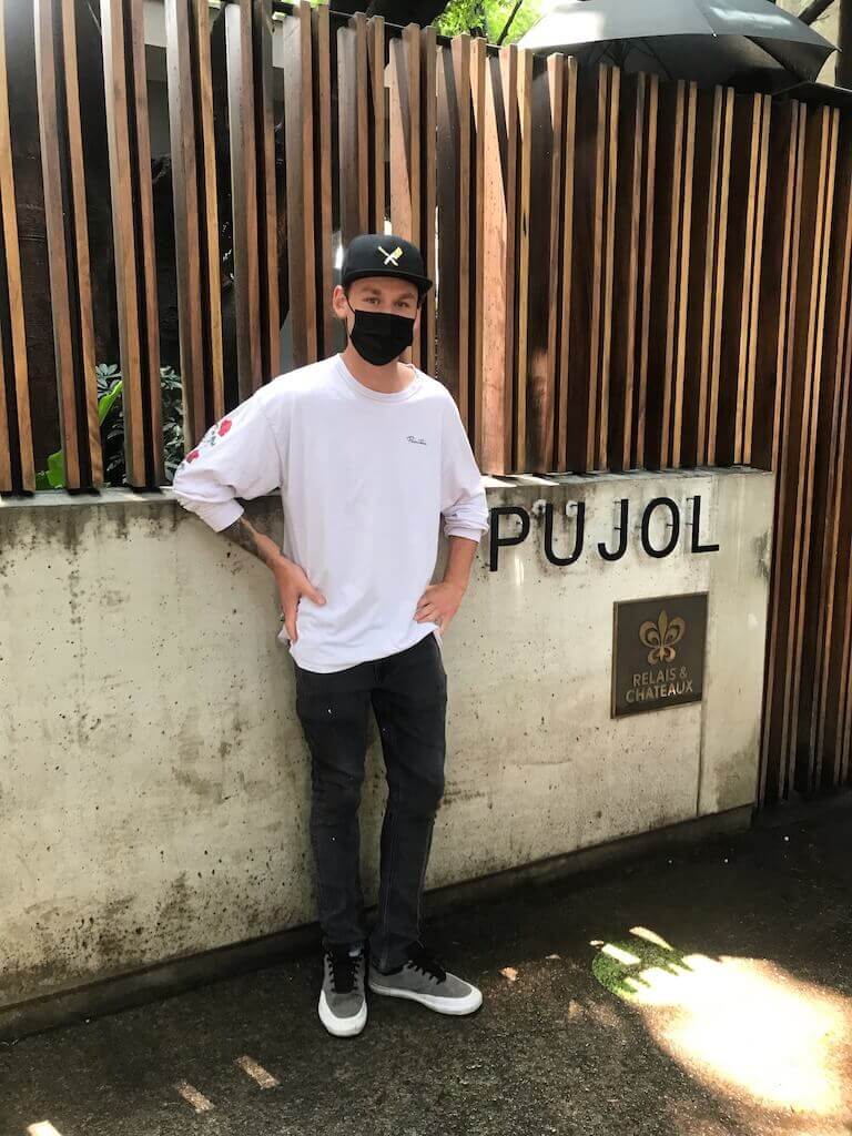 Escoffier graduate Parker Wilks-Bryant stands in front of Pujol sign