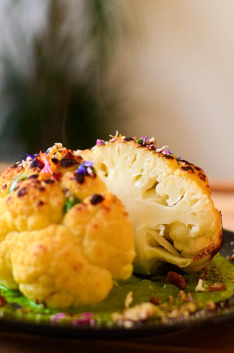 Grilled cauliflower with seasonings on a piece of lettuce