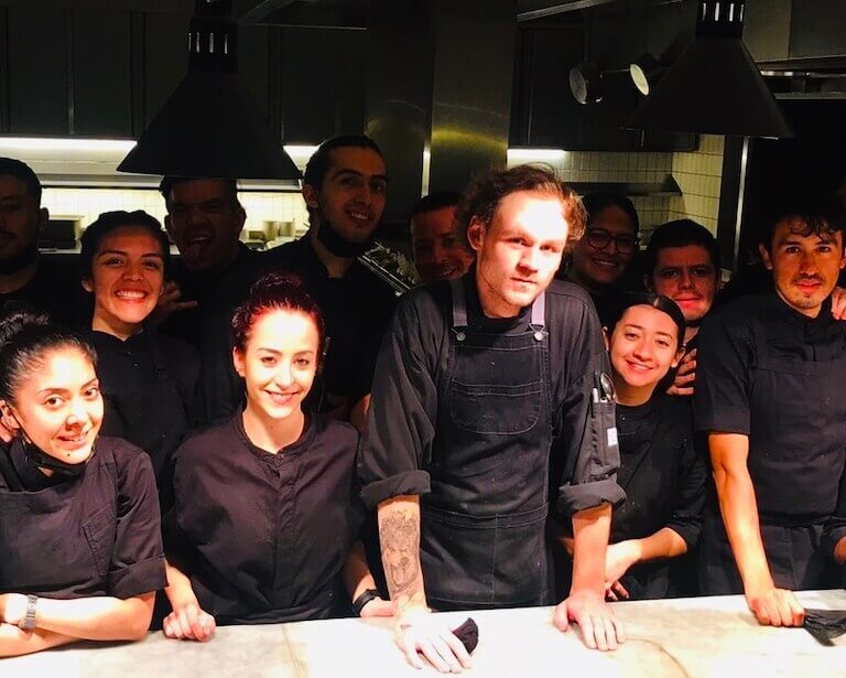 Parker Wilks-Bryant with his coworkers at Pujol in the kitchen