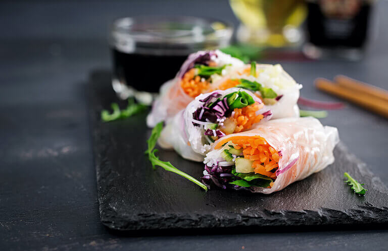 Vegetarian Vietnamese spring rolls with spicy sauce, carrot, cucumber, red cabbage and rice noodle. 