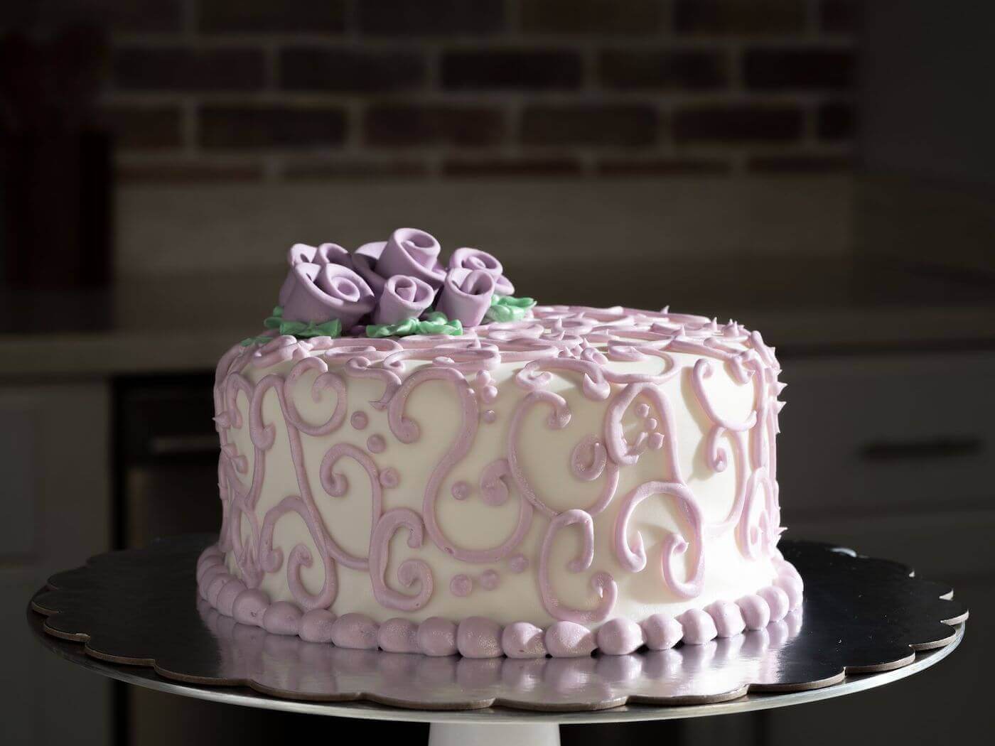 White cake decorated with purple details and flowers
