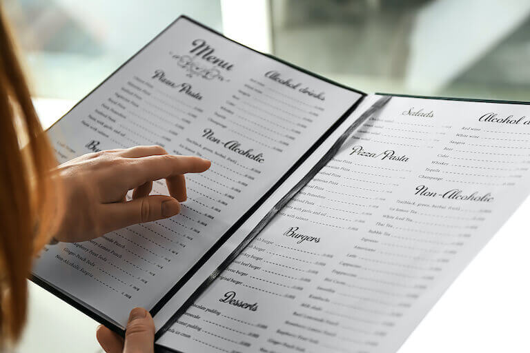 Photo looks over the shoulder of a person who is reading a menu.