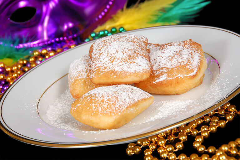 Beignets on a plate with Mardi Gras decor