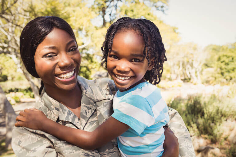 A woman in a military uniform posing for a photo with a child 