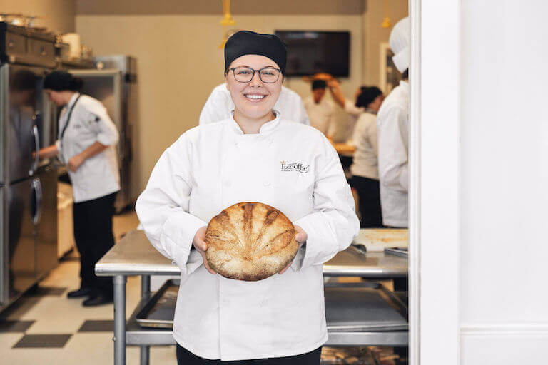 Escoffier baking and pastry student holding baked bread