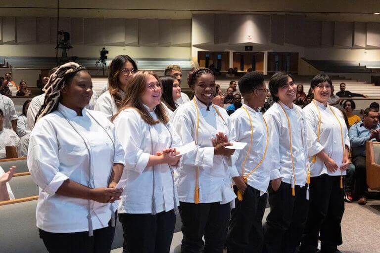 Escoffier students clapping in the audience at graduation
