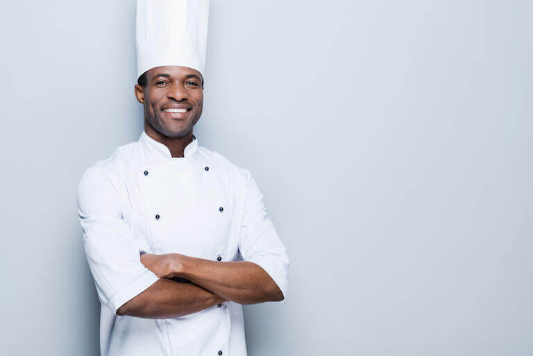 Smiling male chef with white coat and hat