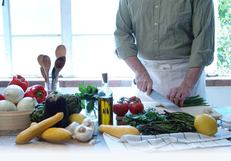chef chopping asparagus and other vegetables with knife