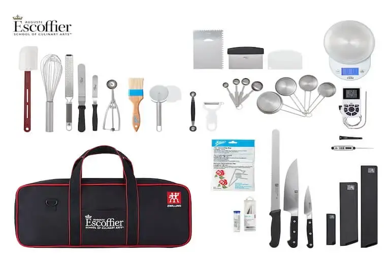 Escoffier culinary toolkit laid out on white background showing knives, whisk, spatulas, pastry tips, scale, thermometer, knife roll, and other professional baking tools