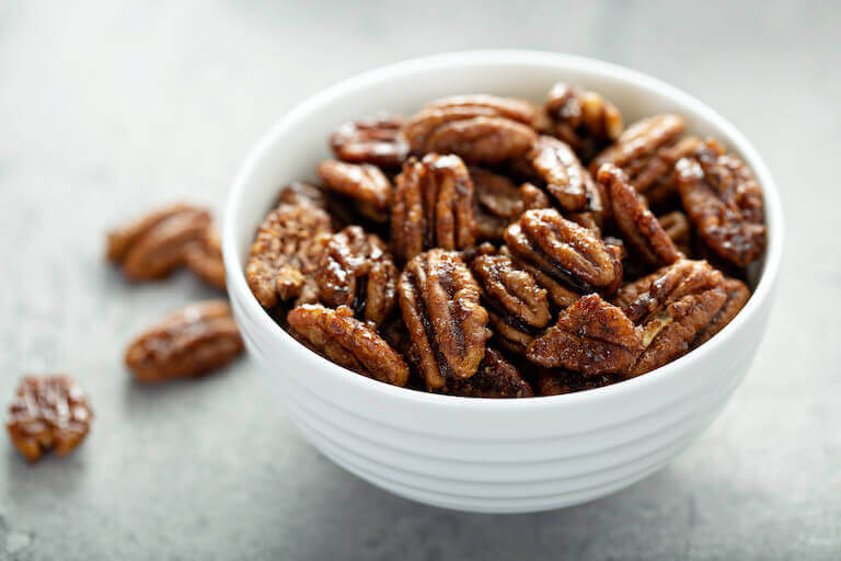 Candied pecans in a white bowl