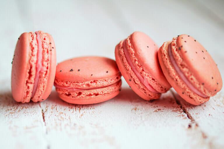 Close up photo of pink macarons on a white table