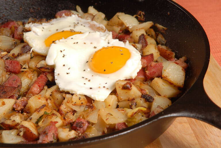 Corned beef hash in a skillet with potatoes and eggs