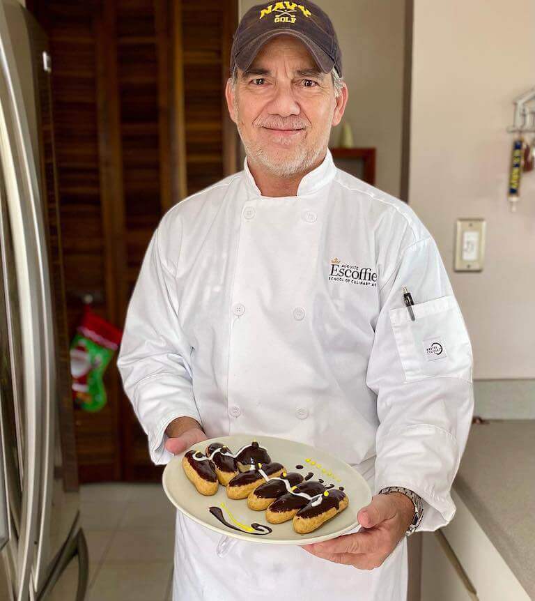 Escoffier student holding eclairs on a white plate