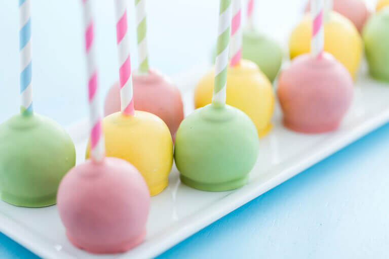 Pastel cake pops on a white serving dish