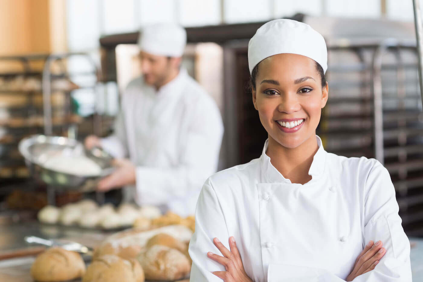 https://www.escoffier.edu/wp-content/uploads/2022/04/Smiling-female-chef-in-a-bakery-with-loaves-of-bread-1400.jpg