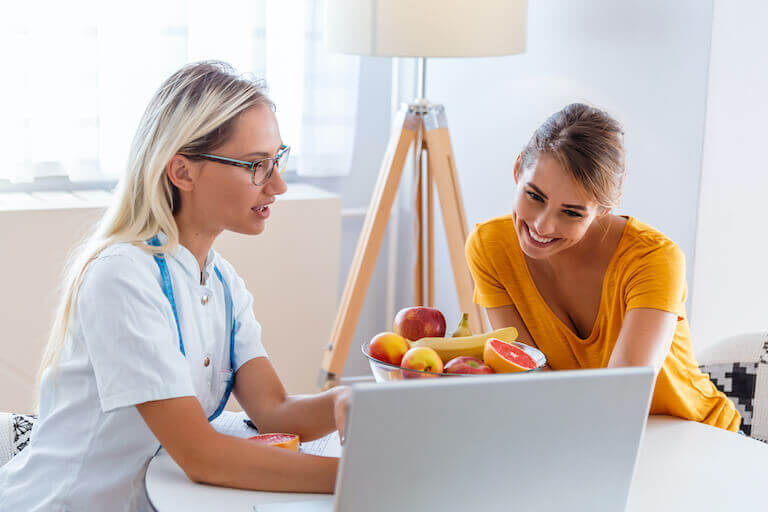 professional nutritionist meeting a patient in the office and healthy fruits