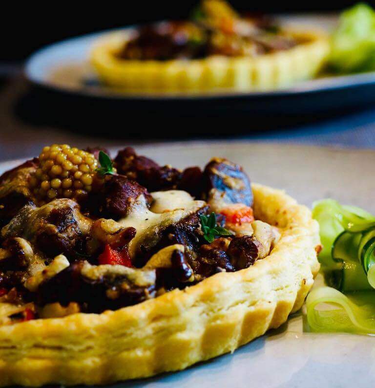 A mushroom and walnut tart with fresh thyme and pickled mustard seeds by Escoffier student
