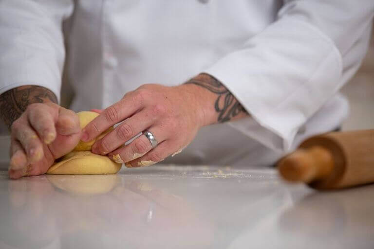 Close up of chefs hands kneading pasta dough